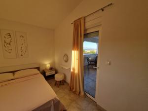 a bedroom with a bed and a door to a balcony at Apartments Rosa Soldatica in Vir