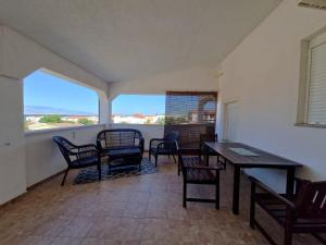 a room with a table and chairs and a balcony at Apartments Rosa Soldatica in Vir