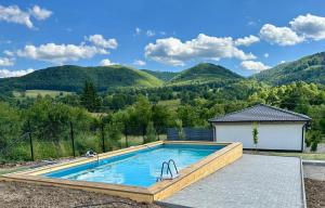 a swimming pool with mountains in the background at Căsuțele Gemenii in Blidireasa