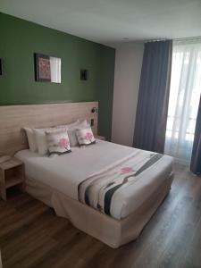 a bedroom with a large bed with green walls at Hotel Modern Est in Paris