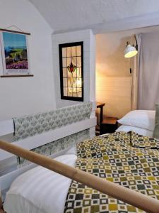 a bedroom with two beds and a stained glass window at Farmhand Cottage in Narberth