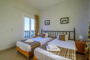 Dos camas en una habitación con ventana. en Luxury 3 Bedroom Apt. in El Gouna with amazing view, en Hurghada