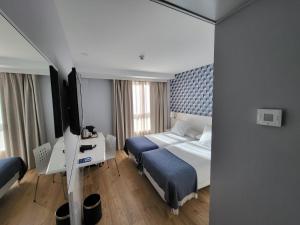a hotel room with a bed and a television at Hotel Monte Rozas in Las Rozas de Madrid