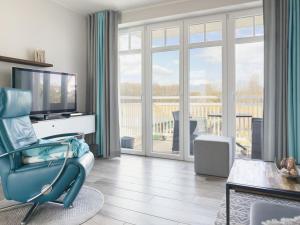 a living room with a blue chair and a television at Ferienwohnung Baltic Lounge 53 in Haffkrug