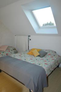 a bedroom with a bed with a window at La Dunette, un nid douillet entre mer et campagne in Carolles