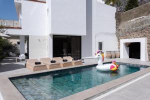 ein Schwimmbad mit einem Schwan in der Mitte eines Hauses in der Unterkunft Karat Villa Stone in Adeje