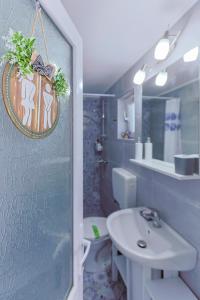 a bathroom with a sink and a toilet and a mirror at Casa EMMA in Jurilovca +14 photos