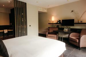 a hotel room with a bed and a desk and chairs at Hotel Gastronomique de Echoput in Apeldoorn