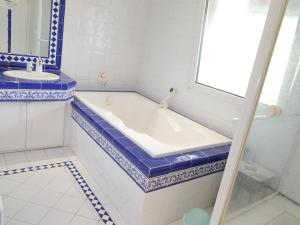 a blue and white bathroom with a tub and a sink at Maison de vacances avec piscine à 20min des plages in Castelnau-le-Lez +16 photos