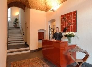 un homme assis à un bureau dans une pièce dans l'établissement Hotel Residence Baiadelsole, à Laigueglia
