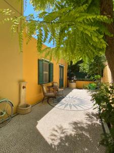 Un patio con mesa y sillas y un edificio. en Maison Masse - Historic Residence with Private Courtyard, en Rodas