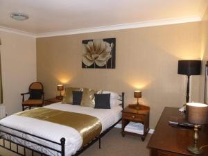 a hotel room with a bed and a desk and a table sidx sidx at Dartmoor Lodge Hotel in Ashburton