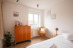 a bedroom with a bed and a dresser and a window at Cozy Townhouse near Lille - 3 Guests in Lambersart