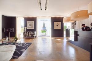 a living room with a counter and a person in a room at Farol Hotel in Cascais
