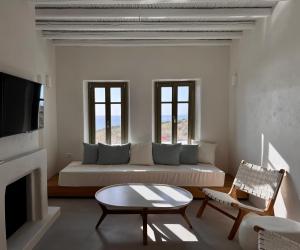 a living room with a couch and two windows at Serifos Bliss in Rámos