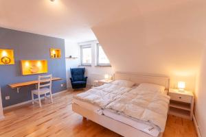 a bedroom with a bed and a desk and a table at Ferienhaus Holzwurm in Braunlage