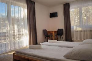 a hotel room with two beds and a window at Noclegi Pod Lyskami in Nowy Targ