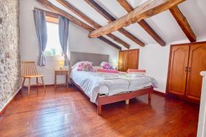 Un dormitorio con una cama y suelo de madera. en La Ferme, en Razac-dʼEymet 25 fotos más