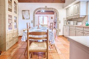 Un comedor con una mesa y sillas en una cocina. en La Ferme, en Razac-dʼEymet