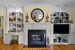 a living room with a fireplace and a mirror at Lake Escape - Lake Waccamaw home in Lake Waccamaw