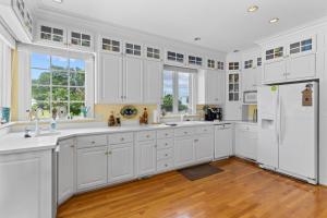 a kitchen with white cabinets and a refrigerator at Lake Escape - Lake Waccamaw home in Lake Waccamaw +34 photos