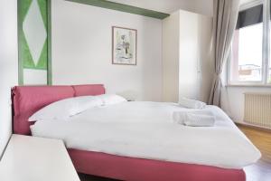 a bedroom with two beds and a red headboard at Appartamento Sole in Belluno