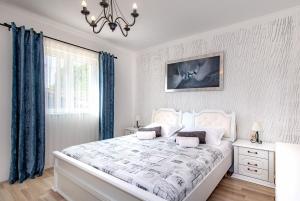 a white bedroom with a large bed and a chandelier at Villa Silente in Oklaj +63 photos