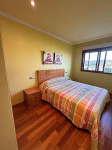 a bedroom with a bed and a window at Playa Castro in Aguiño