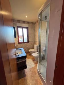 a bathroom with a toilet and a glass shower at Playa Castro in Aguiño +10 photos