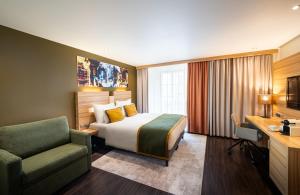 a hotel room with a bed and a chair at Leonardo Boutique Hotel Salzburg Gablerbräu in Salzburg
