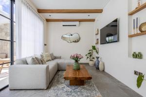 a living room with a couch and a coffee table at Villa Tofino Premium by Tofino Villas in Uluwatu