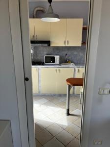 a kitchen with yellow cabinets and a table at Monolocale Solana 6 in Cavo