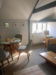 Una sala de estar con mesa de comedor y sillas. en Devon Country Retreat The Linhay at Collaton Farm, en Newton Ferrers
