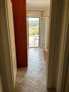 a hallway with a door open to a room with a patio at Monolocale Solana 6 in Cavo +2 photos