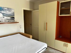 a bedroom with a white bed and a cabinet at Monolocale Solana 6 in Cavo