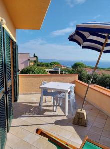 a white table and an umbrella on a patio at Monolocale Solana 6 in Cavo