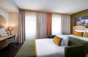 a hotel room with a bed and a desk at Leonardo Boutique Hotel Salzburg Gablerbräu in Salzburg