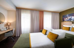 a hotel room with a bed and a desk at Leonardo Boutique Hotel Salzburg Gablerbräu in Salzburg