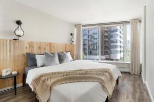 ein Schlafzimmer mit großem Bett und großem Fenster in der Unterkunft Downtown Cityview Escape with Pool and Jacuzzi near Rogers Arena in Vancouver