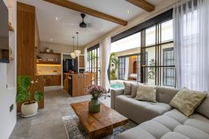 a living room with a couch and a table at Villa Tofino Premium by Tofino Villas in Uluwatu