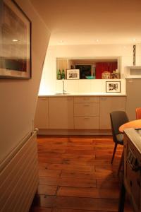 una cucina con armadietti bianchi e pavimenti in legno di De Buitenmuur - Vintage Suite & Bohemian Loft, elk met Privé-ingang en Jacuzzi a Turnhout