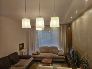 a living room with a couch and a tv at Main apartment Rezidenca in Tirana