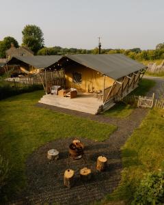 a large tent with a grill and some logs at Butterfly Riverdale Yorkshire in West Tanfield