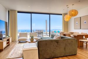 ein Wohnzimmer mit Couch und großem Fenster in der Unterkunft Villa Arco-Iris, a Home in Madeira in Arco da Calheta