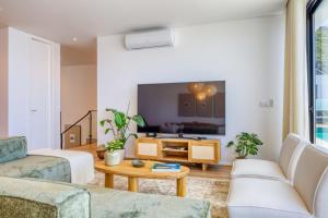 ein Wohnzimmer mit Sofa und Fernseher in der Unterkunft Villa Arco-Iris, a Home in Madeira in Arco da Calheta