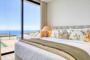 ein Schlafzimmer mit großem Bett und Blick auf das Meer in der Unterkunft Villa Arco-Iris, a Home in Madeira in Arco da Calheta