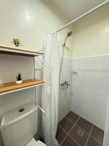 y baño blanco con ducha y aseo. en Spacious Condo Studio Unit in Mactan Cebu, en Lapu Lapu City 29 fotos más