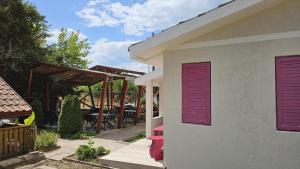 a house with purple shutters on the side of it at Obelisc Costinesti in Costinesti