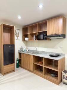 Una cocina con gabinetes de madera y un fregadero. en Spacious Condo Studio Unit in Mactan Cebu, en Lapu Lapu City