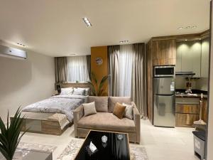 a bedroom with a bed and a couch and a kitchen at Luxury Studio House 392-1 in 6th Of October